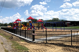 This portion of the playground was moved further from the road and a new, safer fend was installed.